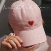 Rosa Cap mit roter Herz- und Oh Happy Day-Stickerei aus verschiedenen Perspektiven und in sommerlichen Lifestyle-Szenen