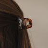 Haarspange klein Herz Amber im Half-Up auf braunem Haar, Fokus auf marmorierte Optik und Herz-Ausschnitt.