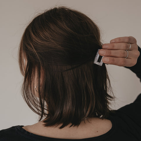 Hand befestigt kleine Haarspange eckig in Perlmutt-Optik im halboffenen Haar