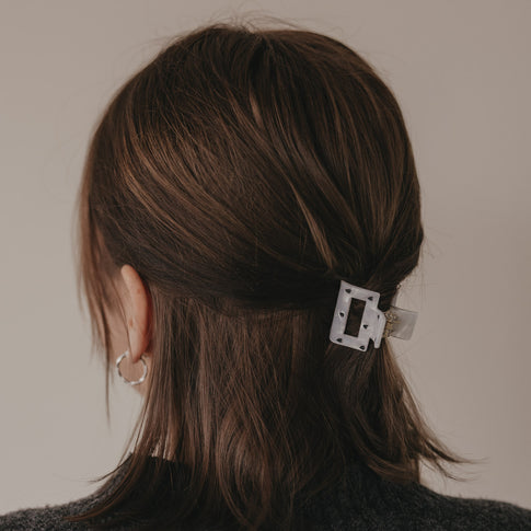 Kleine Haarspange eckig mit schwarzen Herzen in Perlmutt-Optik im Haar getragen