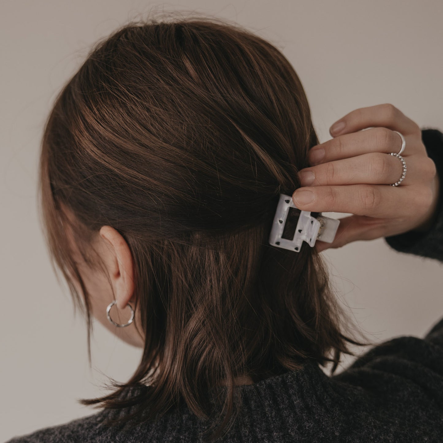 Hand befestigt kleine eckige Haarspange mit schwarzen Herzen im Haar