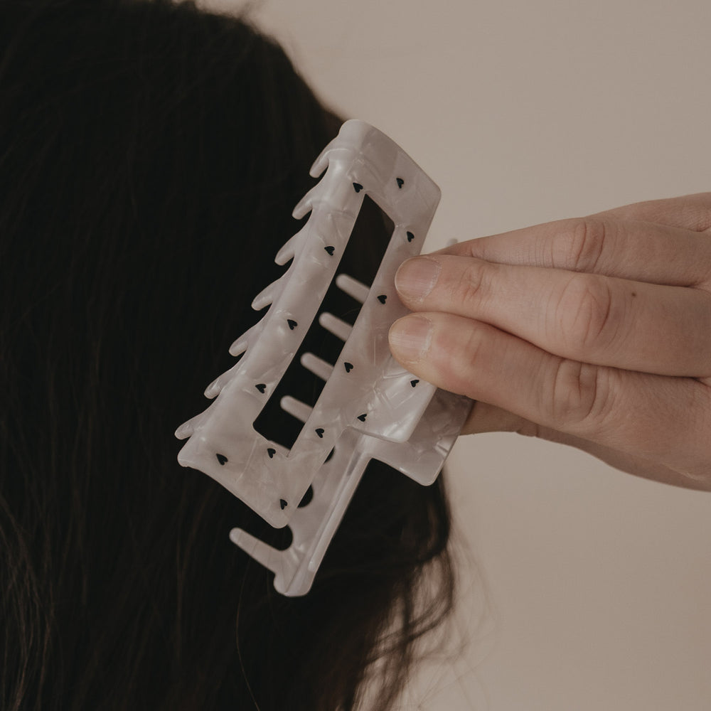 Detail der maxi Haarspange eckig in Perlmutt-Optik mit schwarzen Herzen im Haar