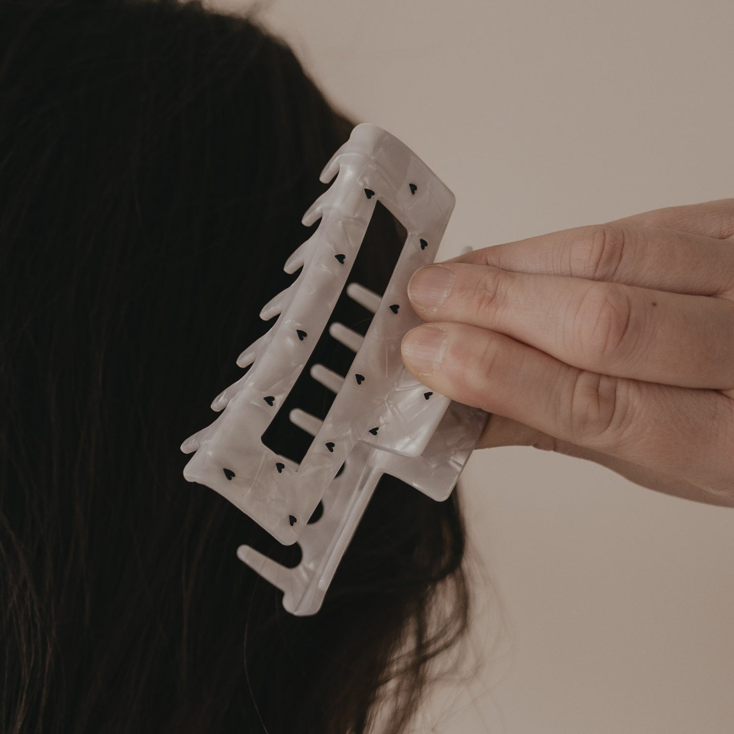 Detail der maxi Haarspange eckig in Perlmutt-Optik mit schwarzen Herzen im Haar