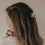 Seitliche Ansicht Haarspange Blume mint im braunen Haar getragen