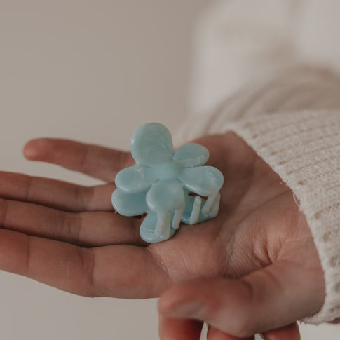Hand hält Haarspange Blume mint zur Ansicht