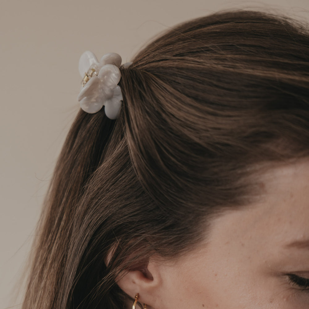 Detail Haarspange Blume in Perlmutt-Optik im zusammengebundenen Haar