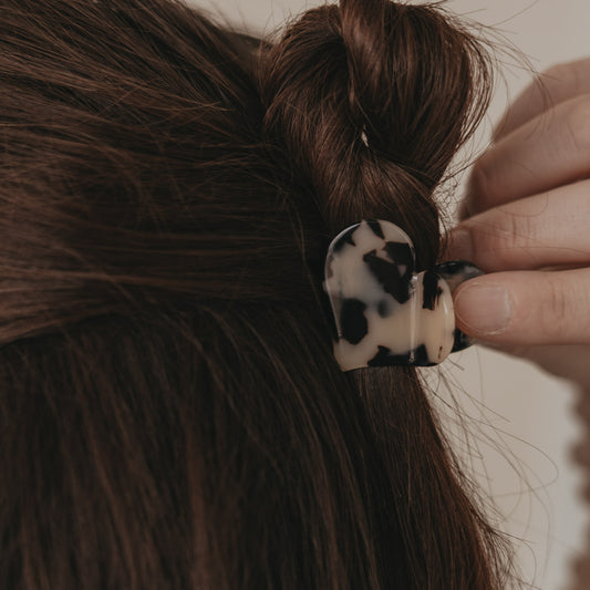 Detail große Haarspange Herzform im Leo-Design beim Befestigen im Haar