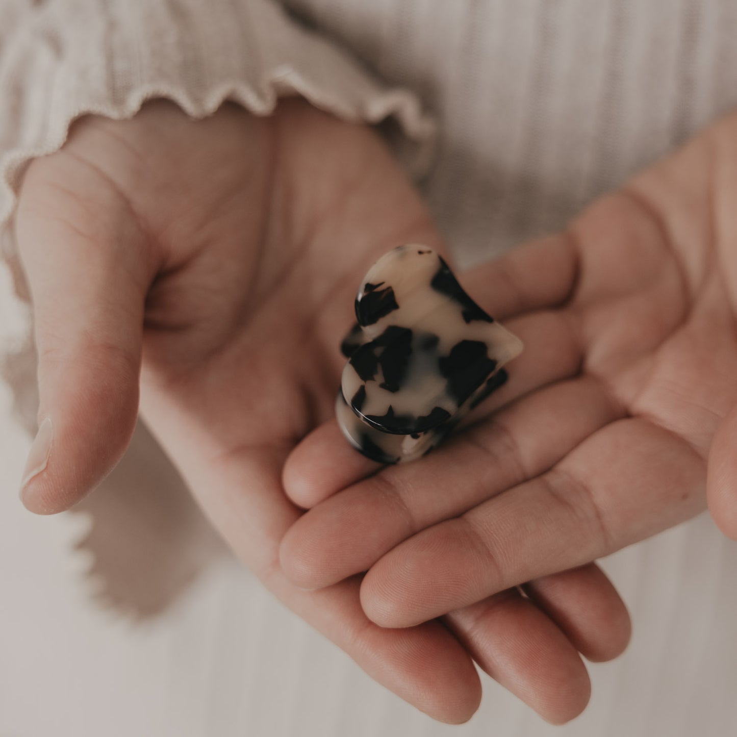 Große Haarspange in Herzform mit Leo-Muster in der Hand präsentiert