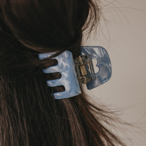 Detailaufnahme kleine blaue Haarspange mit Herzöffnung im Haar