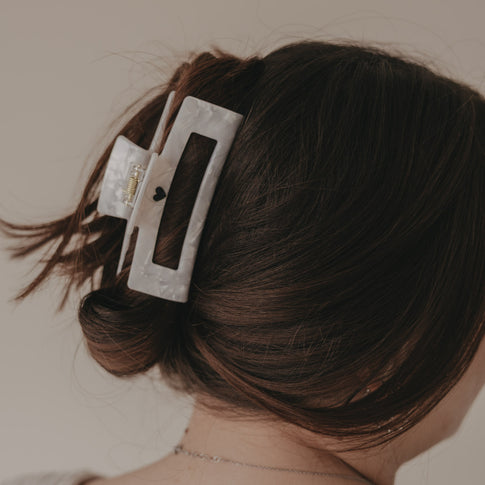 Maxi eckige Haarspange in Perlmutt-Optik mit schwarzem Herz im Dutt getragen