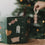 Eulenschnitt Adventskalender neben einem Weihnachtsbaum beim Aufhängen eines Baumanhängers