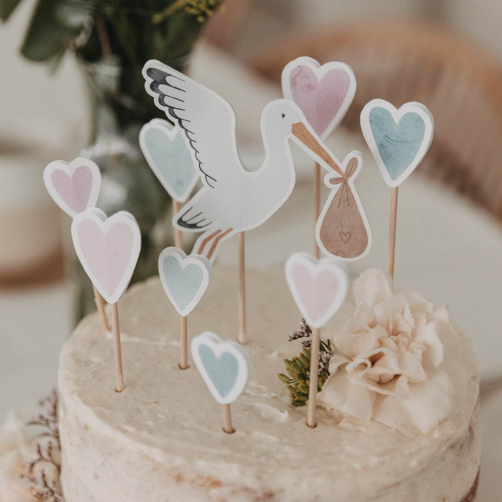 Hier ist die Detailansicht des Storch-Caketoppers mit rosa und blauen Herzen von Eulenschnitt. Bequem von zu Hause aus selbst basteln. 