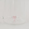 Detailansicht der filigranen rosa Herzfigur am Boden der Glaskaraffe.