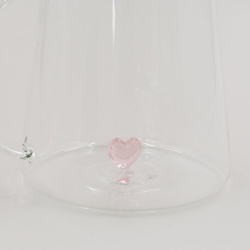 Detailansicht der filigranen rosa Herzfigur am Boden der Glaskaraffe.