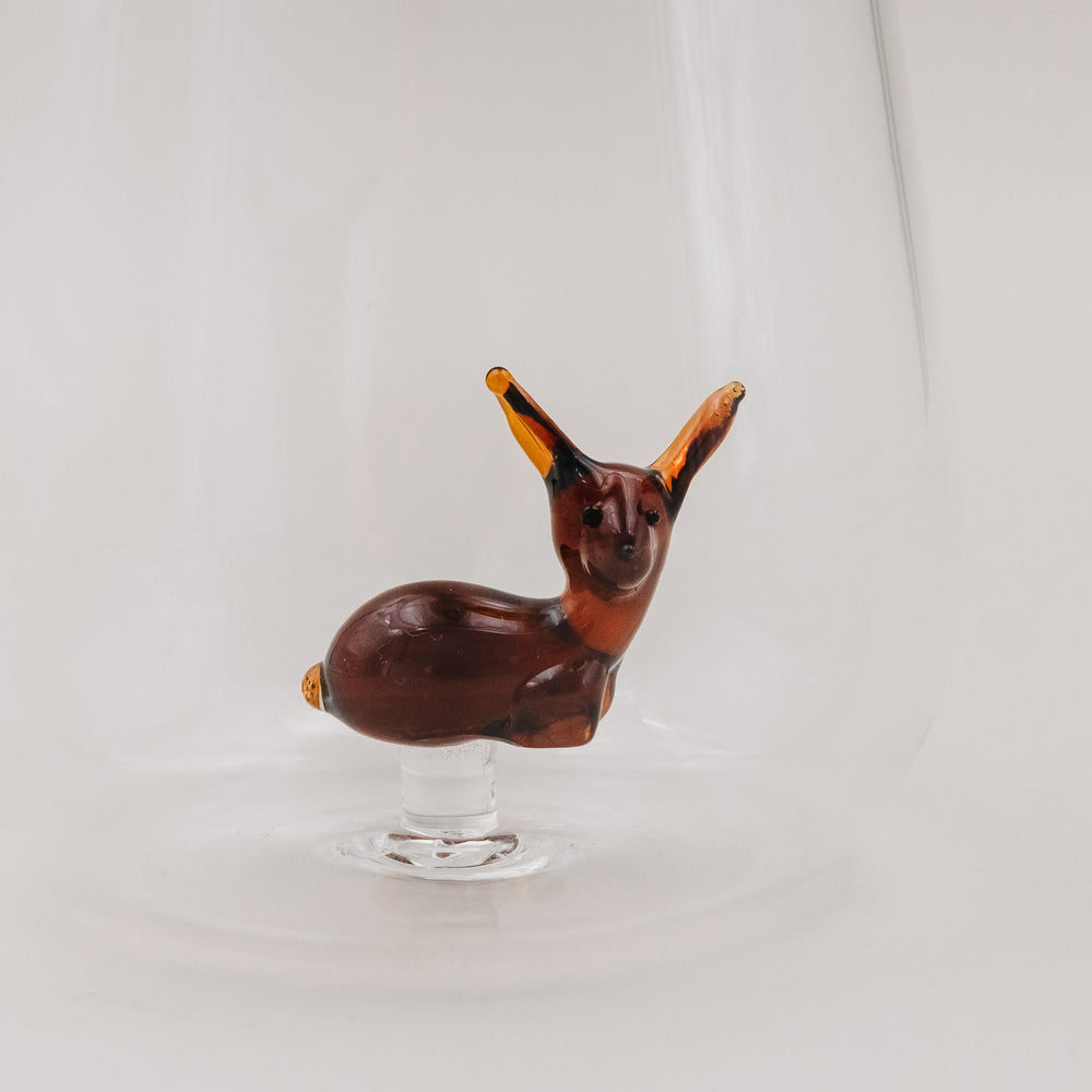 Rehfigur im Trinkglas aus nächster Nähe, braunes Glas mit detaillierten Ohren – handgefertigter Look.
