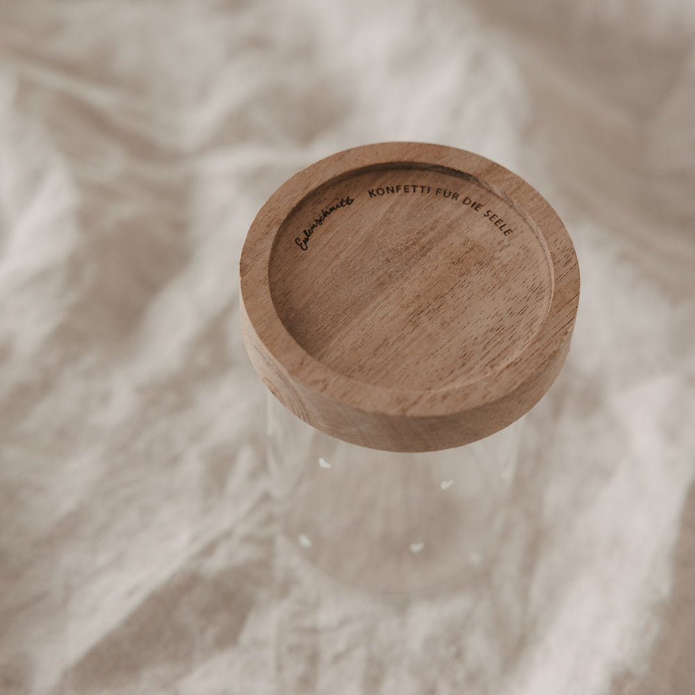 Holzdeckel mit Gravur auf kleinem Glas mit weißen Herzmotiven