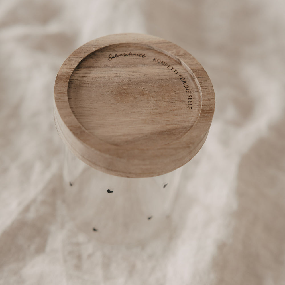Minivorratsglas mit schwarzen Herzen und Holzdeckel auf Stoff