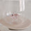 Transparentes Glas mit integrierter Schwein-Figur, dekoratives Doppelwandglas auf hellem Untergrund