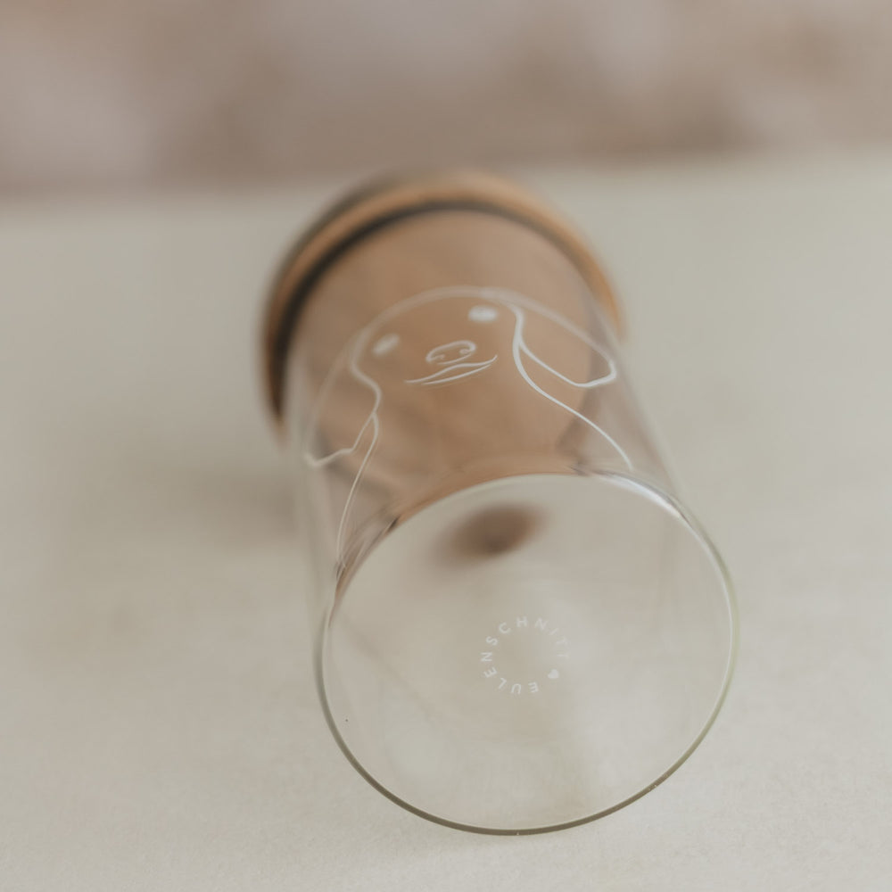 Liegendes Vorratsglas mit Holzdeckel, weißem Hundemotiv und Eulenschnitt-Schriftzug am Glasboden.