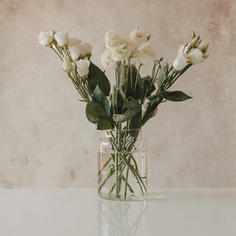 Glasvase mit Herzmuster gefüllt mit weißen Blumenstrauß