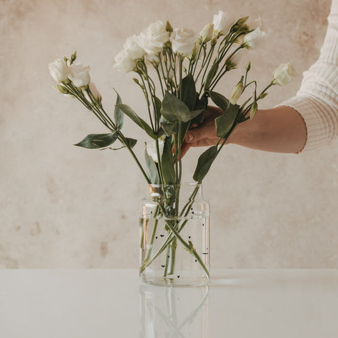 Glasvase mit Herzprint mit locker arrangierten weißen Blumen