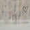 Detail Glasflaschen mit feinen Herz- und Blumenillustrationen im transparenten Design
