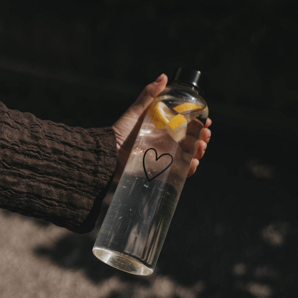 Trinkflasche Herz 750 ml draußen gehalten mit Zitronenstücken im Wasser