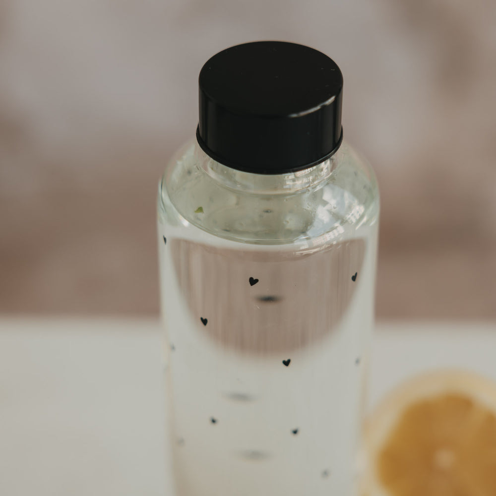 Trinkflasche Glas mit Herzmuster und schwarzem Deckel, Detailansicht oben, minimalistisch inszeniert