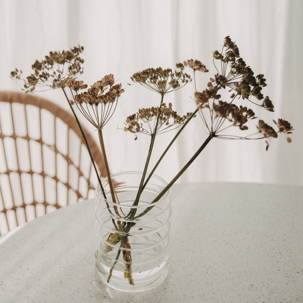 ransparente Bubble Glasvase mit Trockenblumen auf hellem Esstisch im skandinavischen Stil.