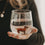 Transparentes Figurenglas mit braunem Dackel im Glasboden, mit Wasser gefüllt und auf einer Hand präsentiert.