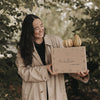 Frau hält Herbstbox mit Kürbissen im Freien, Geschenkidee für den Herbst mit Naturdeko und liebevoller Verpackung.