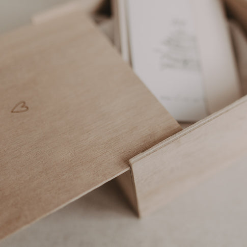 Nahaufnahme des Holzdeckels der Erinnerungsbox Herz beim Aufschieben, mit Blick auf den Inhalt.