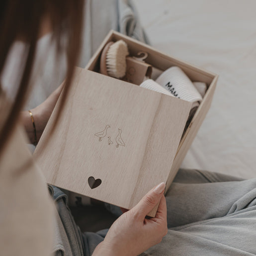 Holz Erinnerungsbox mit Gänsemotiv und Herzdetail, gefüllt mit Babygeschenk, stilvolle Aufbewahrung für Erinnerungen