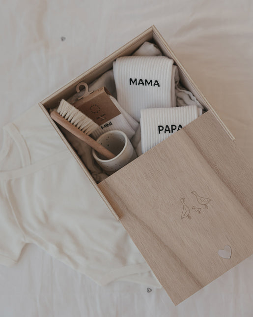 Holzbox mit Gänse Gravur, gefüllt mit Babyaccessoires wie Socken und Bürste, ideale Erinnerungsbox zur Geburt