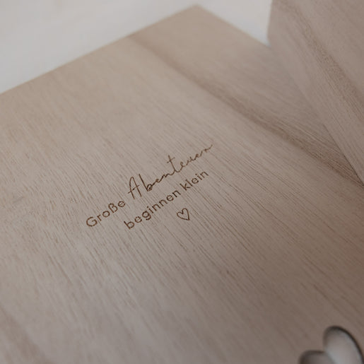 Detailaufnahme Gravur „Große Abenteuer beginnen klein“ auf Holzbox, liebevolle Geschenkidee zur Geburt