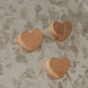 Drei Herzmagnete aus Holz mit individueller natürlicher Maserung auf einer Magnettafel