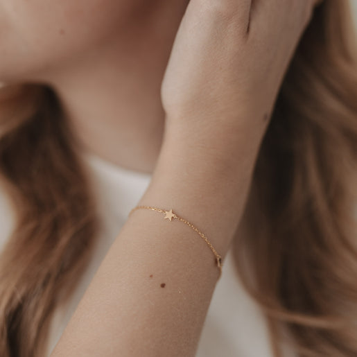 Detailaufnahme vom Armband Jackie Gold mit Sternanhänger am Handgelenk, zart und elegant getragen.