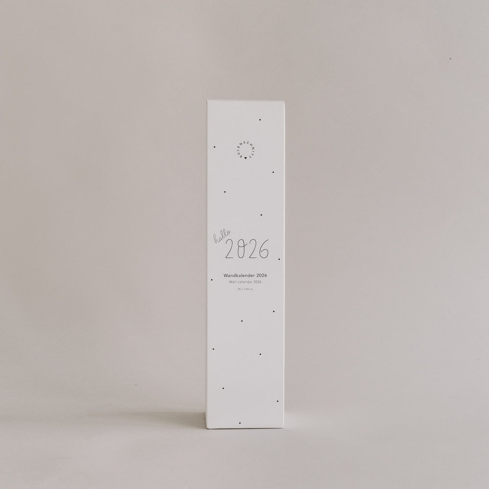 Verpackung des Wandkalenders 2026 mit Aufschrift „hallo 2026“ auf hellem Hintergrund, schlichtes Design im Hochformat.