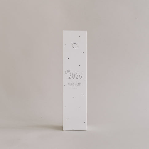 Verpackung des Wandkalenders 2026 mit Aufschrift „hallo 2026“ auf hellem Hintergrund, schlichtes Design im Hochformat.