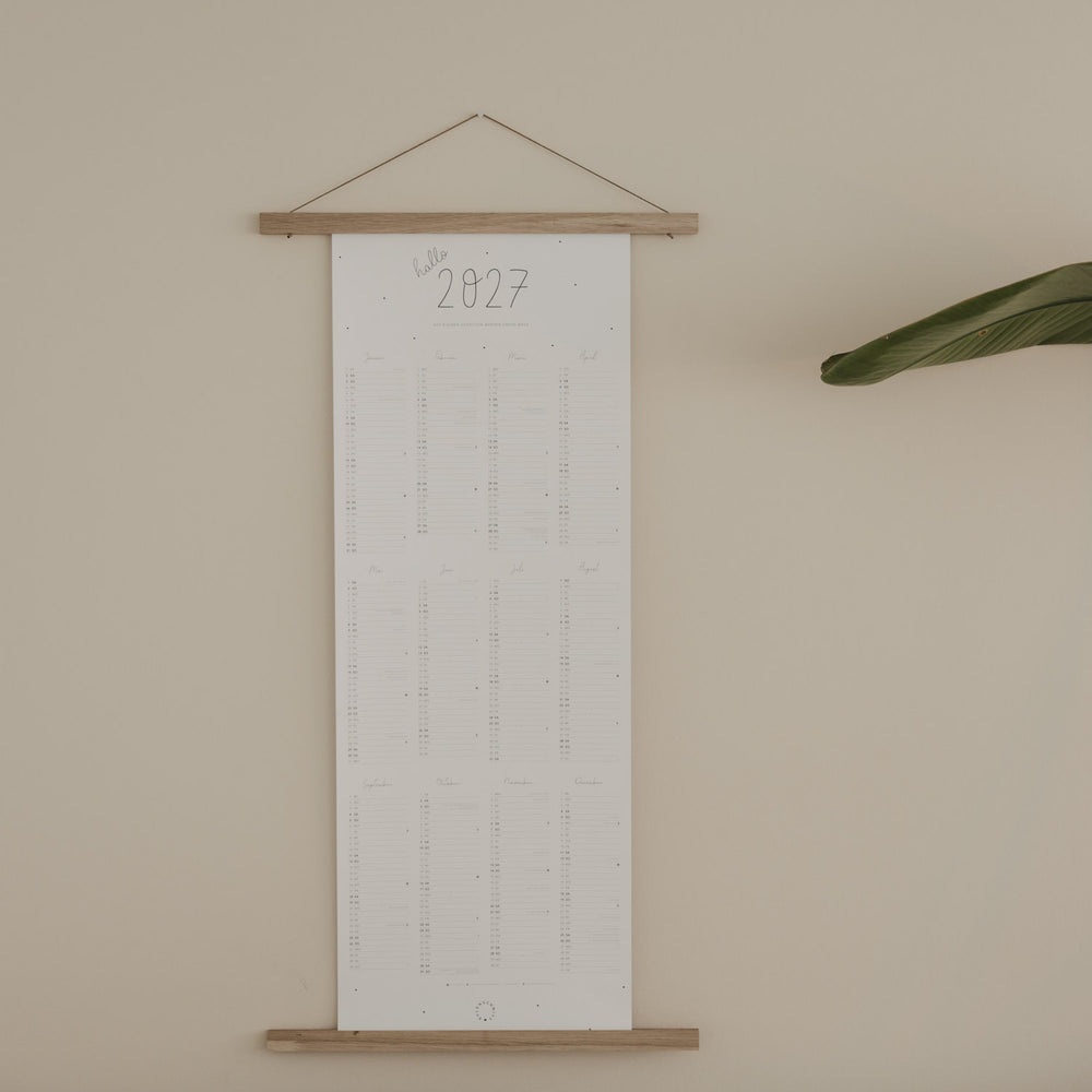 Wandkalender 2027 aufgehängt mit Holzleiste im minimalistischen Stil