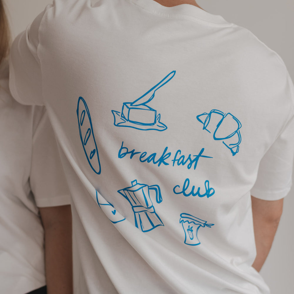 Rückansicht mit Frühstücksillustrationen und „breakfast club“-Aufdruck auf weißem Shirt.