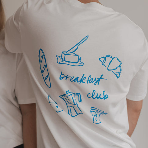 Rückansicht mit Frühstücksillustrationen und „breakfast club“-Aufdruck auf weißem Shirt.