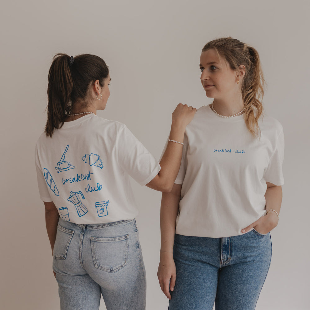 Zwei Personen tragen Breakfast Club Shirts mit Front- und Rückenprint – lässiger Partnerlook in Weiß und Jeans.