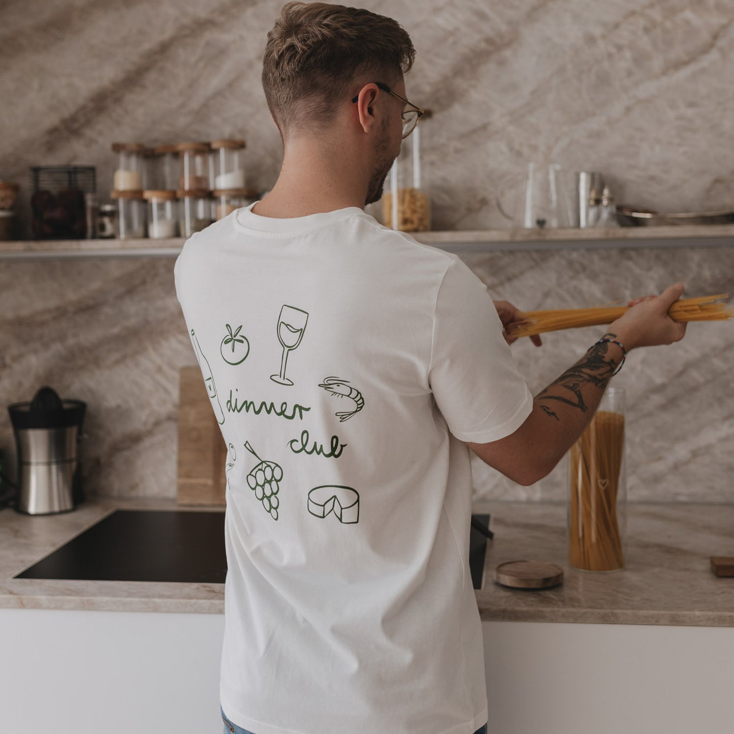 Rückseite des Shirts mit grünem Dinner-Club-Motiv: Weinflasche, Tomate, Weintraube & Co