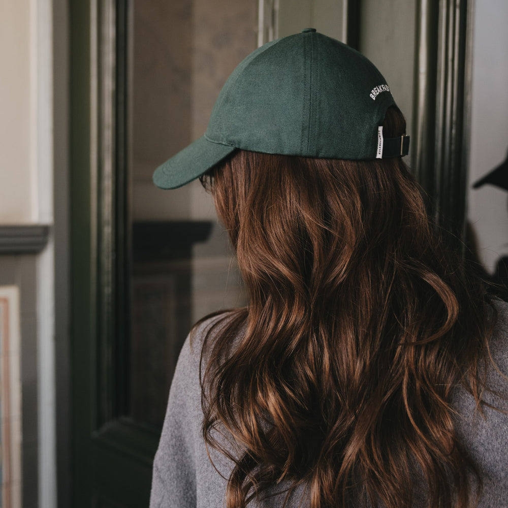 Seitenansicht dunkelgrüne Cap „Breakfast Club“ auf langem braunen Haar