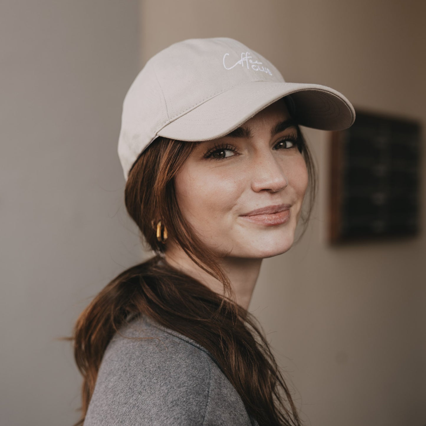 Frau mit taupefarbener „Coffee Club“ Cap im Porträt
