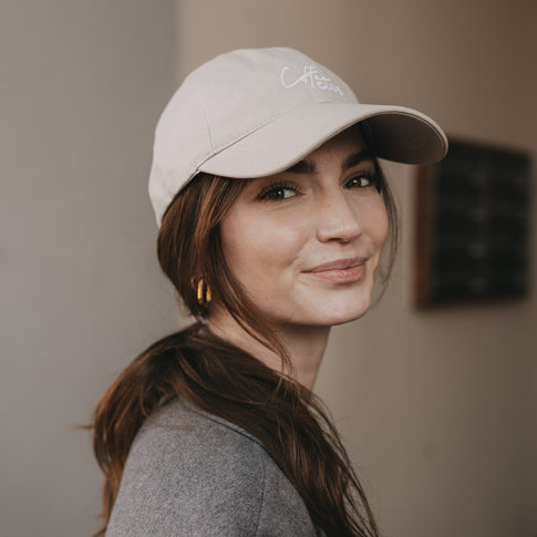 Frau mit taupefarbener „Coffee Club“ Cap im Porträt