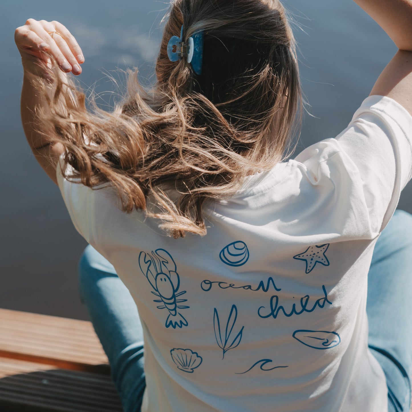 Detail Rückenprint „Ocean Child“ mit Meeresmotiven auf weißem T-Shirt, sommerlicher Look