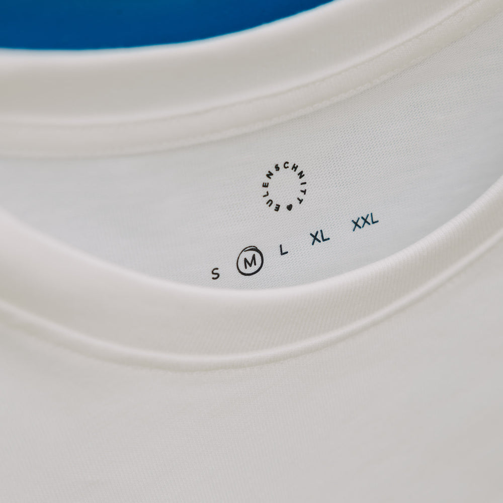 Detail Kragen mit Größenangabe und Eulenschnitt Logo auf weißem T-Shirt