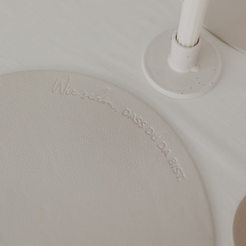 Detailaufnahme des Platzsets in Creme mit Schriftzug „Wie schön, dass du da bist“.